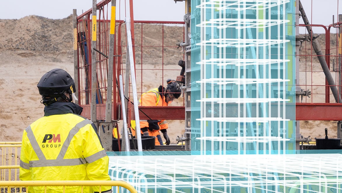 A construction worker views a digital overlay on a job site.