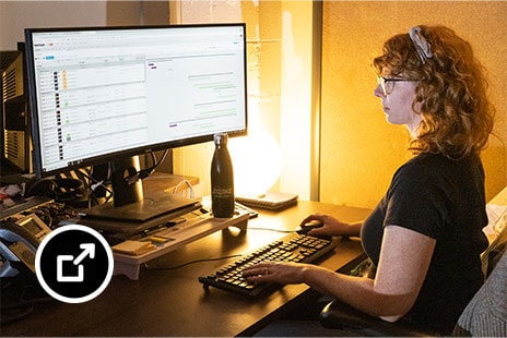 Melissa Gray sits at desk with ShotGrid software on monitor