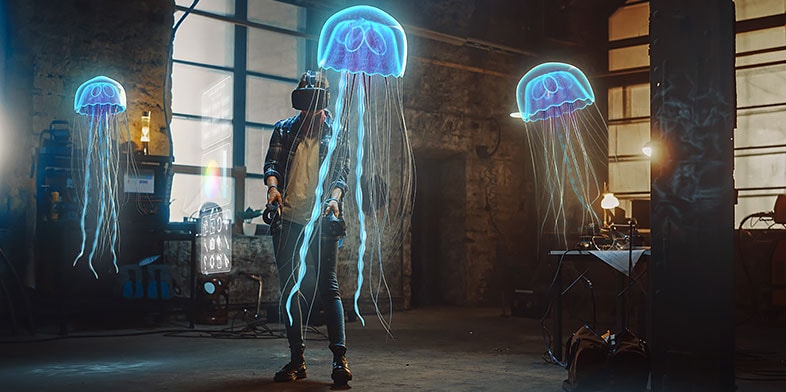 Female artist wearing AR headset uses joysticks to create abstract 3D jellyfish sculpture 