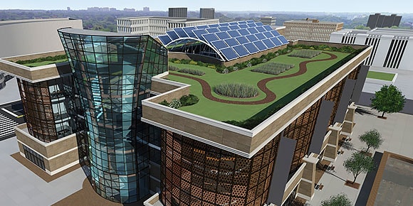 A 2D glass building with a green landscaped rooftop with pathways and solar panels
